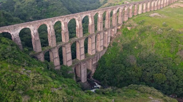 Aqueduct between mountains at sunrise with cloudy sky in arcos del sitio in tepotzotlan state of mexico