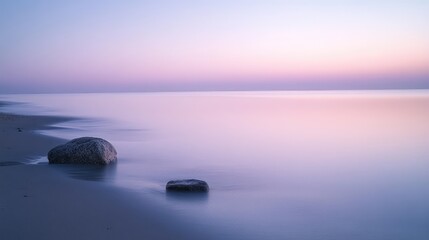 A quiet beach scene at twilight, soft pinks and blues reflecting in the calm waters.