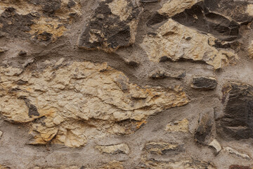 Rough textured stone wall forming a solid background in Vysehrad Prague