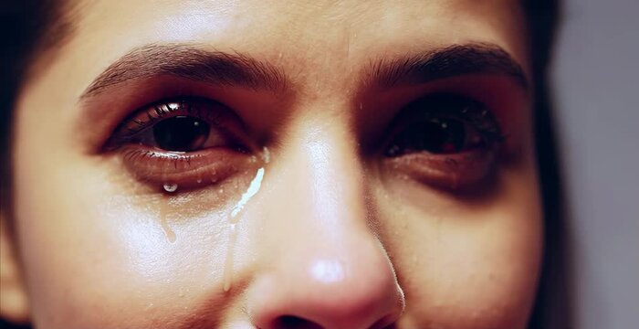 The woman is crying. Close-up eyes and tears.