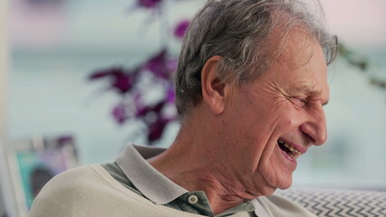 Elderly man pretending to be angry while sitting on the couch, showcasing a playful and humorous...