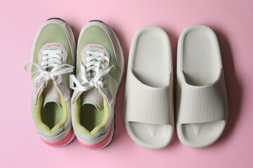 Rubber slippers and sneakers on pink background, top view