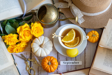 Cup of tea with orange and small pumpkins on white table, September.