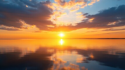 Naklejka premium A vibrant, cloud-filled sky reflecting the golden hues of a setting sun over a calm body of water.