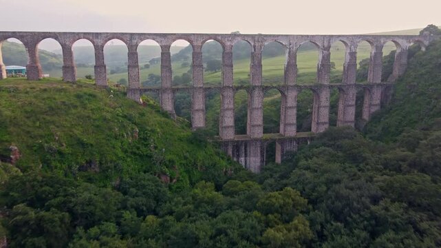 Aqueduct between mountains at sunrise with cloudy sky in arcos del sitio in tepotzotlan state of mexico