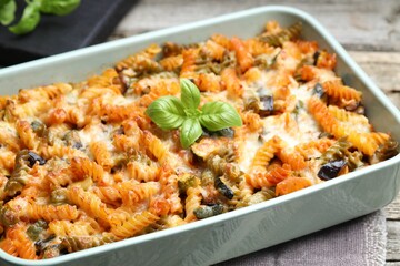 Delicious al forno pasta in baking dish on wooden table, closeup