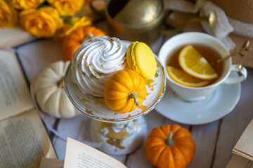 Cup of tea with orange and small pumpkins on white table, September.