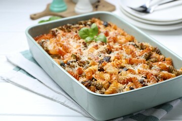 Delicious al forno pasta in baking dish on white wooden table, closeup