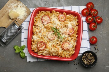 Delicious al forno pasta in baking dish on grey table, flat lay