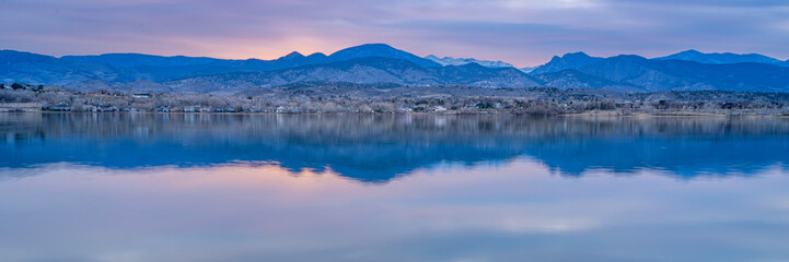 Fototapeta premium dusk over calm lake in Colorado foothills of Rocky Mountains, Boedecker Reservoir in early spring - panorama