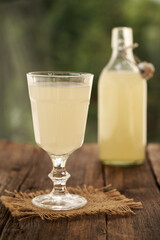 Fresh natural whey in a glass and bottle outdoors - protein rich healthy nutritional supplement