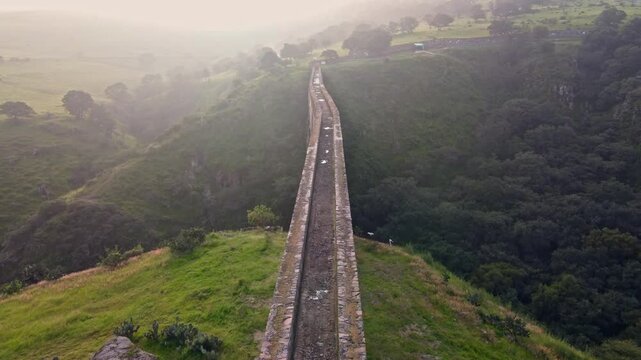 Aqueduct between mountains at sunrise with cloudy sky in arcos del sitio in tepotzotlan state of mexico