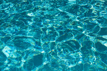 Ripple Water in swimming pool with sun reflection. Wavy water background.