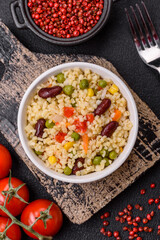 Boiled wheat bulgur porridge with vegetables peppers, peas, corn