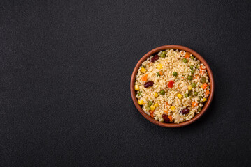 Boiled wheat bulgur porridge with vegetables peppers, peas, corn