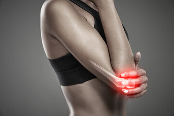 Woman, arm pain and athlete for injury in studio, training accident and red glow on gray...