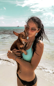 Pretty woman with dog on beach Playa del Carmen Mexico.