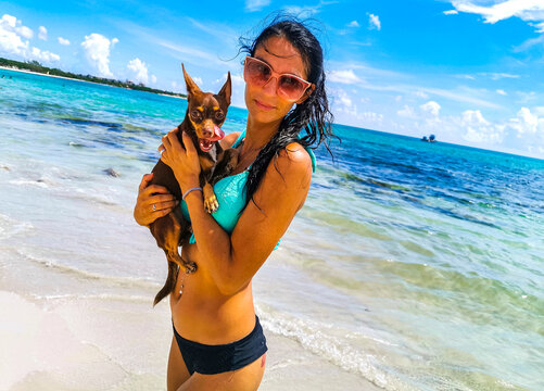 Pretty woman with dog on beach Playa del Carmen Mexico.