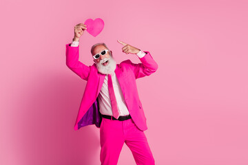 Photo of attractive elderly white hair santa man sunglass winning hold heart dance wear stylish pink suit isolated over pastel background