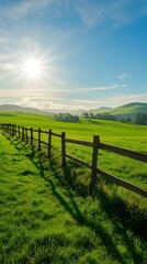 A picturesque rural landscape featuring a vibrant green field with a rustic fence and distant hills under a bright sun