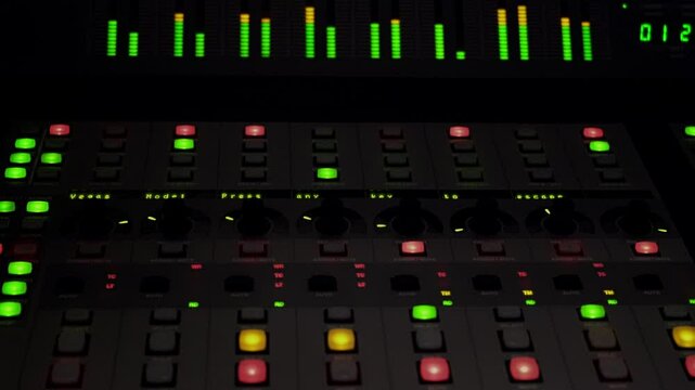 A blinking light of a button knob area and sound metrix meter level was running of a sound mixer panel control.