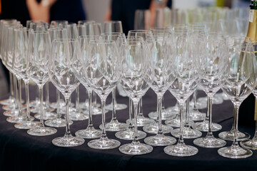 Elegant arrangement of empty wine glasses ready for an event or celebration on a black tablecloth