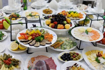 Beautifully arranged table with various dishes including grilled vegetables, fruits, and salads