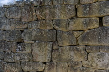 Ancient stone wall with weathered textures and moss.