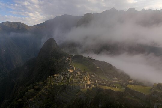 Aerial view of Machu Picchu with mist covering the ruins. - Powered by Adobe