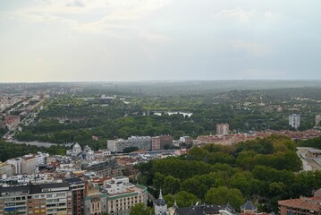 Aerial view of Madrid skyline with green trees and historical buildings.