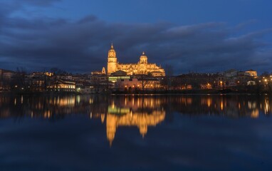 Obraz premium Night view of Salamanca Cathedral reflecting on the Tormes River in Spain