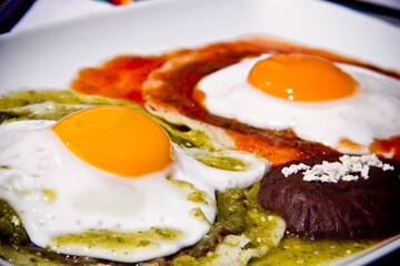 Mexican fried eggs, Huevos Rancheros, with green and red  hot sauce.