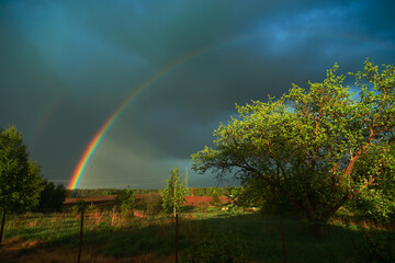 
Rainbow after the storm. View from grandma's window. Country yard and beautiful sky after rain....