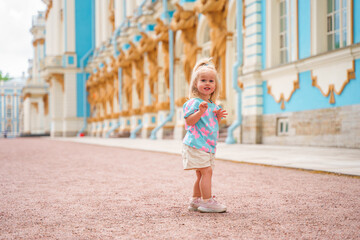 Little girl child walks to Catherine's Park with a palace, family tourism, active childhood.