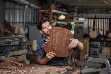 Luthier creating a guitar and using tools in a traditional