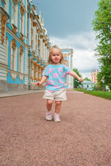 Little girl child walks to Catherine's Park with a palace, family tourism, active childhood.