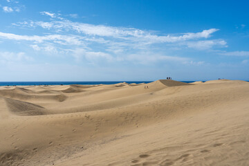 Sand dunes under a clear blue sky by the sea in Maspalomas, Gran Canaria island