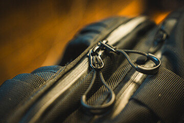 Dual zips on the top of a black backpack; high detail close up. 