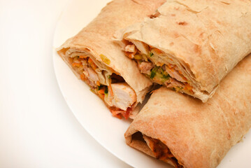 Meat shawarma on a white plate. Burritos with meat.