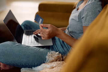 Close up of woman buying online with laptop and credit card.