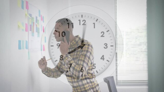 Talking on smartphone, man in office with clock animation overlay - Powered by Adobe