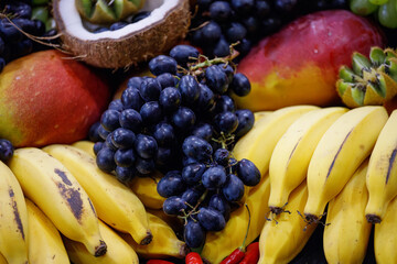 assorted fruits coconut, apple, papaya, grape, kiwi, orange at a street market stall in Rio de Janeiro.