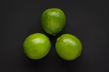 Three (3) Green Limes on black background