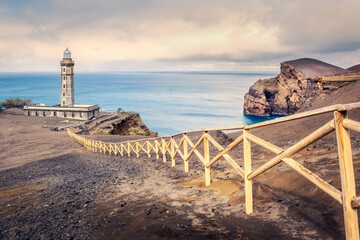 Lighthouse of Ponta dos Capelinhos scenic view with dramatic sky and warm colors, Azores