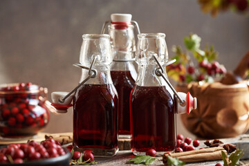 Three bottles of medicinal wine prepared from fresh hawthorn berries ans spices
