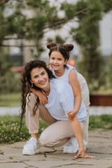 Naklejka premium Happy mom and daughter are relaxing in the city park