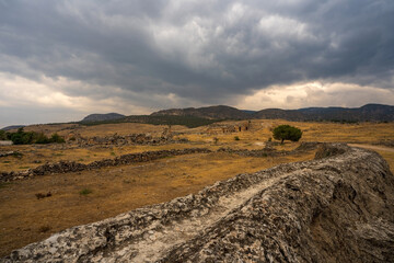 Hierapolis in Pamukkale: A desolate path winds through the arid landscape, leading towards ancient...