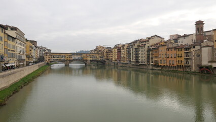 Obraz premium Florence, Italy - decembre 27 2024: Sunny Tuscany with iconic Ponte Vecchio, Florence skyline historic architecture, Arno River reflections. A colorful blend of Renaissance culture, medieval landmarks
