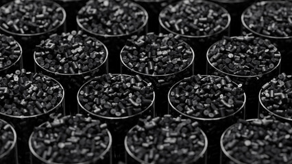 Grid of glasses filled with black plastic polypropylene granules, masterbatch polymer grain, with shallow DOF. HDPE or PVC resin pellets. 3d render illustration