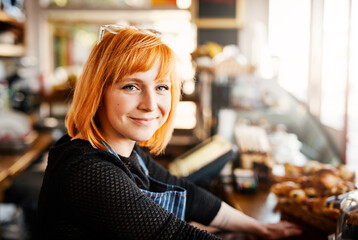 Portrait, barista or woman by counter in coffee shop, customer service and cashier working in cafe. Bistro startup, small business and female owner with smile for store management, serving and waiter